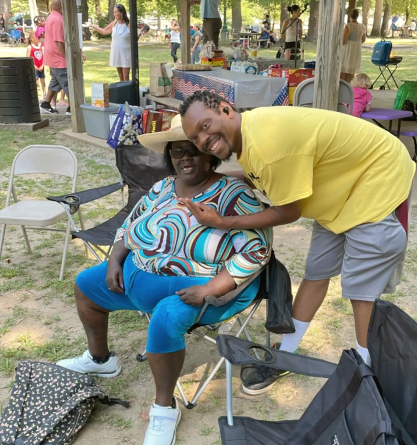 A man leaning in to hug a woman at a picnic.